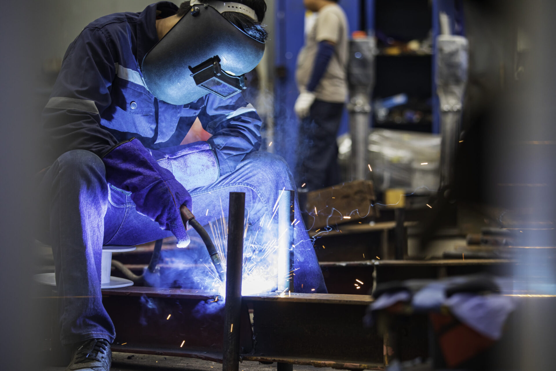 Welding male worker metal steel is part of beam structure plate construction.